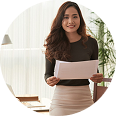 Professional woman holding documents, smiling, in a well-lit office setting, representing personalized insurance services and financial planning at Amerus Financial.
