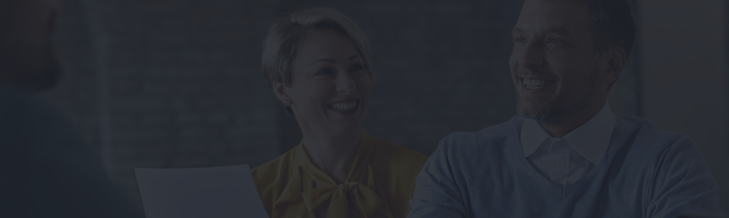 Smiling couple discussing life insurance options in a professional setting, reflecting personalized guidance from Amerus Financial.