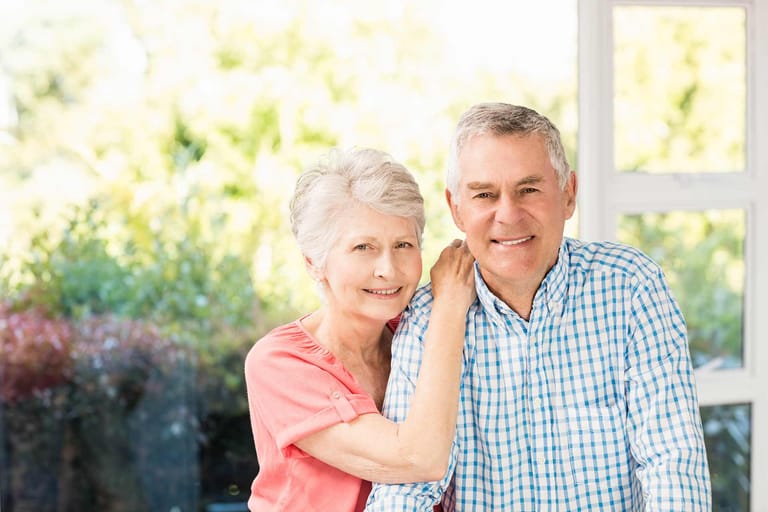 Smiling senior couple posing together, representing the importance of Medicare and senior insurance services.