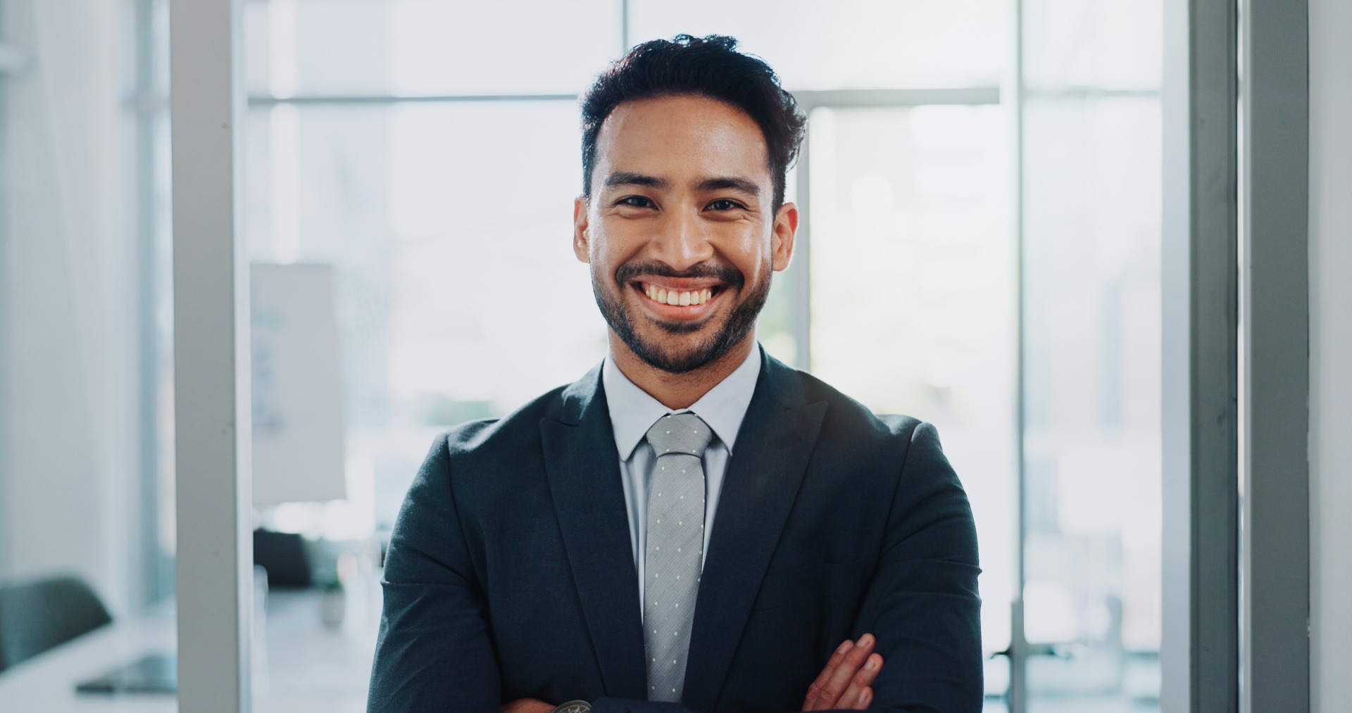 Smiling professional man in a suit, representing Amerus Financial, emphasizing expertise in managing healthcare plans.