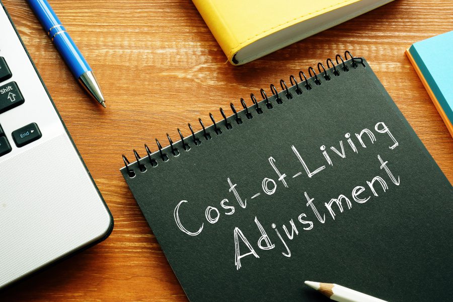 desk with pc and notebook that says cost of living adjustment