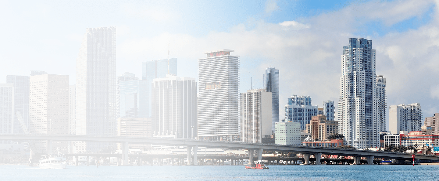City skyline of Miami, Florida, featuring modern high-rise buildings and a bridge over water, representing the urban landscape relevant to Florida insurance laws and regulations.