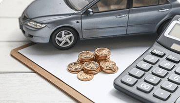 model of a car on a clipboard with a calculator and pennies