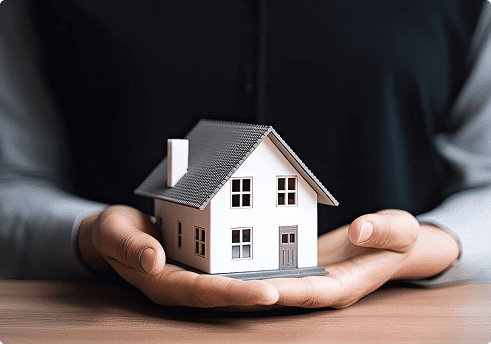 man holding a model of a house