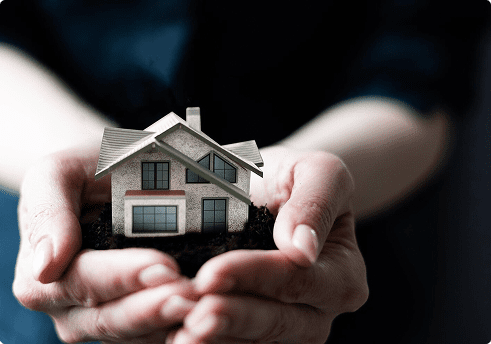 man holding a model of a house