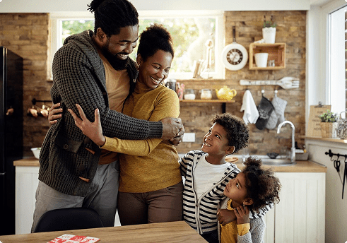 family in kitchen hugging each other